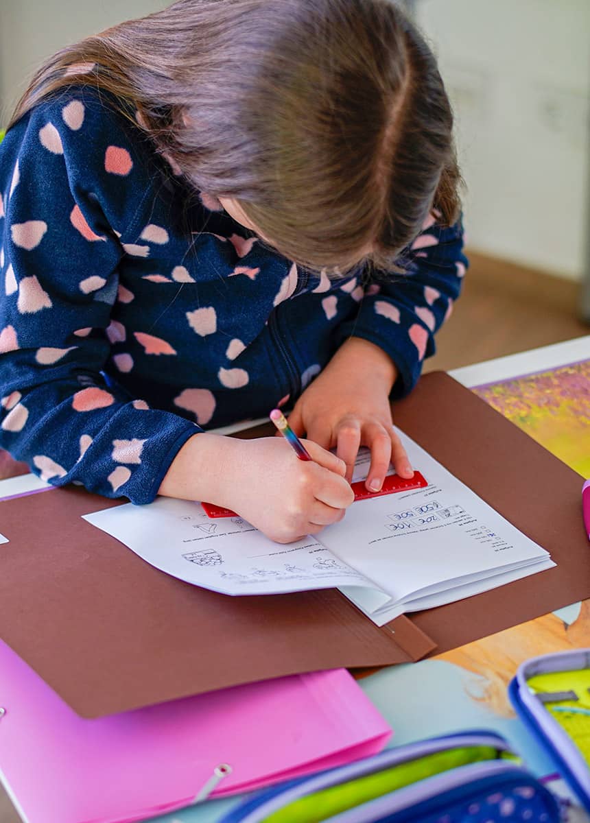 Schülerin Klasse 3 löst Aufgaben in ihrem Heft